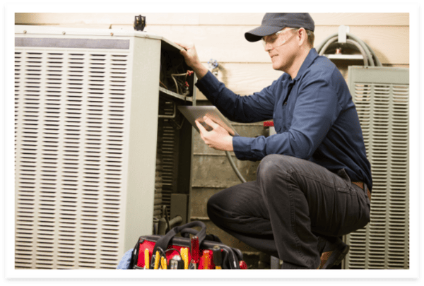 HVAC Maintenance professional performing maintenance on outdoor AC system.