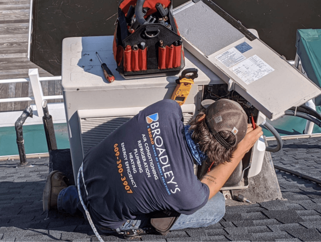 Broadley's professional checking a rooftop unit.