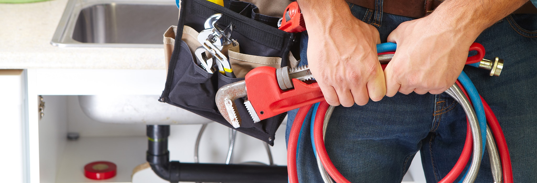 Plumber with Plumbing tools on the kitchen. Renovation.