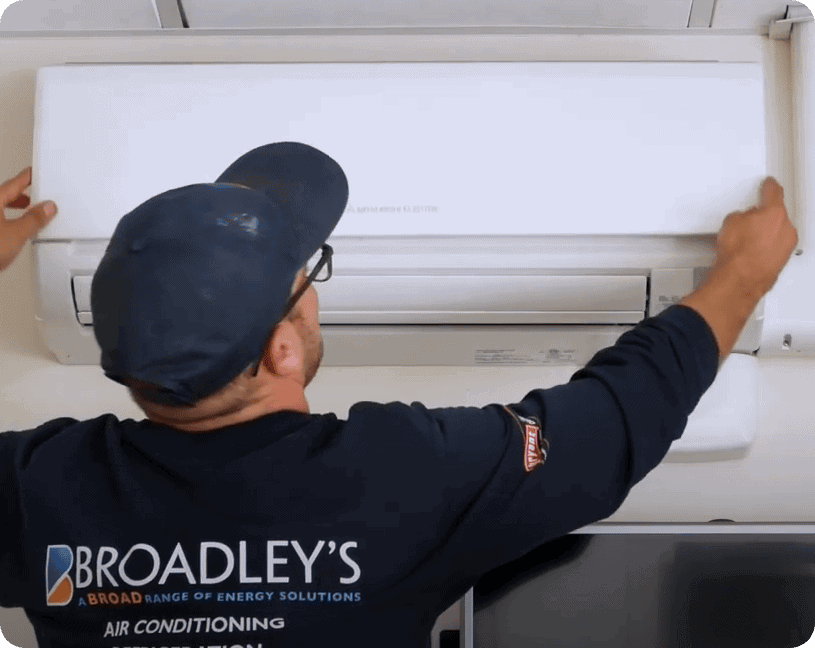 Broadley's tech removing a Mitsubishi Ductless Mini-Split cover panel.